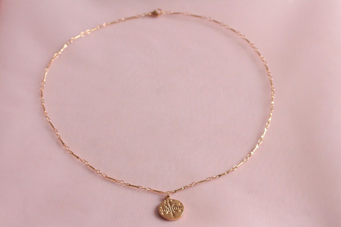 Collier doré avec médaille rose des vents